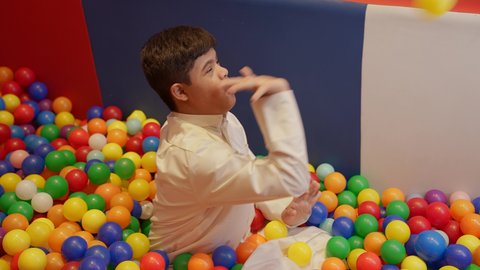 اوقات التسلية و الترفيه ، الاستمتاع باللعب في العطلة الصيفية ،قضاء اوقات رائعة في مدينة الملاهي ، طفل سعودي مصاب بمتلازمة داون في مدينة الألعاب ، يلعب في حوض الكور البلاستيكية