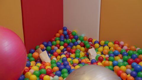 Having a wonderful time at an amusement park. A Saudi child with Down syndrome at the amusement park plays in a plastic ball pool. Fun and entertainment times. Enjoying summer vacation.