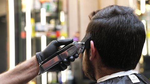 صالون تجميلي رجالي لتصفيف الشعر،الاعتناء بالمظهر الخارجي و النظافة البدنية، استخدام المشط و ماكينه الخلاقة, تقديم خدمات العناية الشخصية، ممارسة مهنه الحلاقة, تصوير مقرب ليد حلاق عربي خليجي سعودي يقوم بحلاقة شعر الزبون