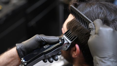 الاعتناء بالمظهر الخارجي و النظافة البدنية، زيارة لصالون تجميلي رجالي، استخدام المشط و ماكينه الخلاقة, تقديم خدمات العناية الشخصية، ممارسة مهنه الحلاقة, تصوير مقرب ليد حلاق عربي خليجي سعودي يقوم بحلاقة شعر الزبون