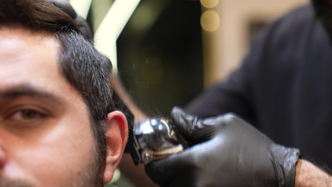 زيارة لصالون تجميلي رجالي، استخدام المشط و ماكينه الخلاقة, تقديم خدمات العناية الشخصية، ممارسة مهنه الحلاقة, تصوير مقرب ليد حلاق عربي خليجي سعودي يقوم بحلاقة شعر الزبون