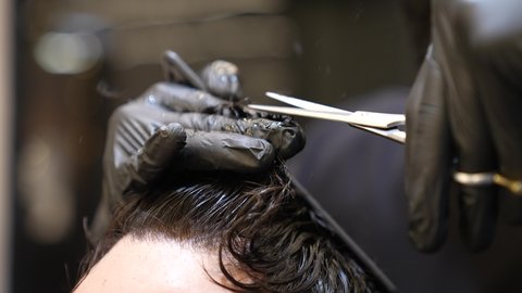 العناية والاهتمام بالجمال والأناقة والمظهر الخارجي، استعمال ادوات المقص و المشط, تقديم خدمات العناية الشخصية، الممارسة مهنه الحلاقة, تصوير مقرب ليد حلاق عربي خليجي سعودي يقوم بحلاقة شعر الزبون