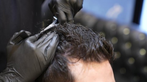 تقديم خدمات الحلاقة و قص الشعر، تقديم خدمات العناية الشخصية، ممارسة مهنه الحلاقة, تصوير مقرب ليد حلاق عربي خليجي سعودي يقوم بحلاقة شعر الزبون