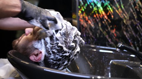 Barbering, providing personal care services, hair care and personal hygiene, close-up of a Saudi Arabian Gulf barber washing a customer's hair, the concept of hair care and attention