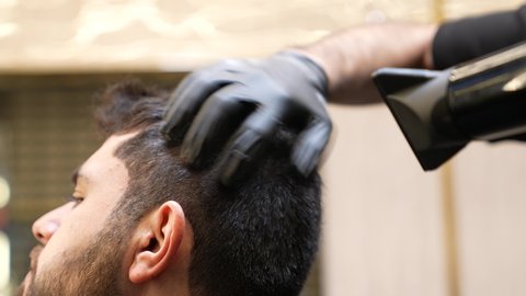 الاهتمام بالشعر و النظافة البدنية، ترتيب وتمشيط الشعر، الإهتمام بالمظهر الخارجي، العناية بالجمال، تصوير مقرب ليد حلاق عربي خليجي سعودي يقوم بعمل سيشوار لشعر الزبون ، روتين العناية بالشعر، تقديم خدمات العناية الشخصية