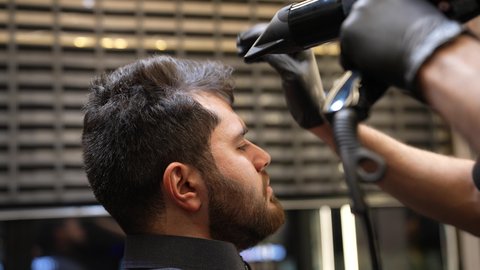Appearance care, beauty care, close-up of a Saudi Arabian Gulf barber blow-drying a customer's hair, hair care routine, personal care services