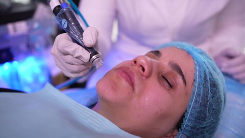 جلسة ليزر في عيادة خاصة، طبيبة عربية خليجية عمانية تستخدام احدث التقنيات لعلاج الوجه، تقديم الخدمات والرعاية الصحية ، فتاة عربية عمانية خليجية تجلس على كرسي العلاج في موعد بعيادة طبية مختصة بالتنظيف والعناية بالبشرة