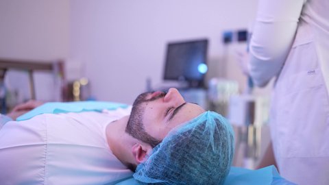 استخدام مكونات تجميلية شبابية ، ترطيب وتقشير وتفتيح الجلد، مفهوم العناية والإهتمام بنضارة وتحسين البشرة، طبيبة عربية خليجية عمانية تستعد لوضع كريم مرطب ، رجل عربي خليجي عماني يجلس على كرسي العيادة