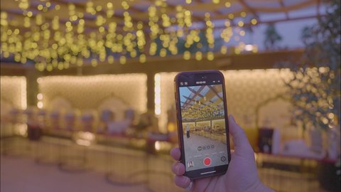 تصوير مقرب ليد رجل سعودى يقوم بالتقاط فيديو لطاولة البوفيه المفتوح في العشاء ،أثاث داخلي راقي لمطعم على الطراز الحديث في المملكة العربية السعودية، الديكورات والتصاميم الداخلية للكافيهات والمطاعم، صالة مطعم ومقهى بديكورات وألوان جذابة