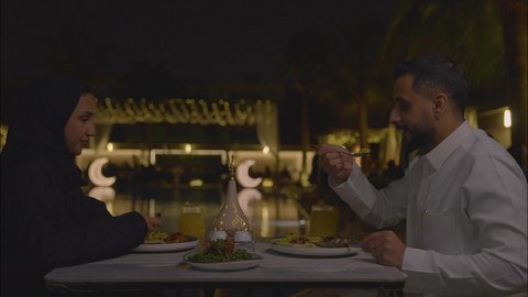 شرب العصائر الطازجة، الاستمتاع بتناول الطعام, زوجان عربيان سعوديان خليجيان يجلسان في مطعم, حوارات ونقاشات على مائدة الطعام, مفهوم الاسره السعيده, قضاء اوقات ممتعه, عطلة نهاية الاسبوع, تعارف وبناء علاقات اجتماعيه ، سفره مليئة بالمأكولات العربية