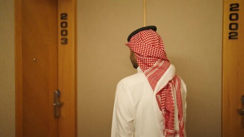 منتجع سياحي فاخر, الإستعداد لبدء الفعاليات الصيفيه, الاستمتاع بالعطلات السياحيه والإجازه الصيفيه, شاليهات راقيه في السعوديه, رجل عربي خليجي سعودي يرتدي الزى التقليدي والشماغ ،يفتح باب غرفة فندقية فاخره، السياحه في المملكه العربيه السعوديه