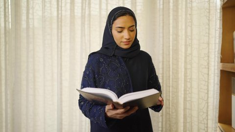 قضاء الوقت بالمطالعة ،تنمية المهارات الفكرية ،  الاهتمام بالعلم والثقافة والدين ،  سيدة عربية خليجية عمانية ترتدي العباءه والحجاب تقف بجانب مكتبة خشبية ، تأخذ منها كتاب وتبدأ بالقراءه ،  تعزيز مفهوم المعرفة ، ممارسة الهوايات المفضلة، الاستمتاع بالهدوء والراحة داخل المنزل