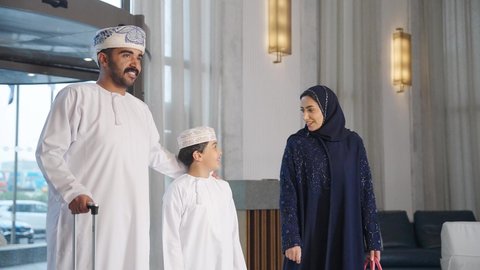 عائله عربية خليجية سعودية تجر حقيبة السفر بالقرب من مكتب الاستقبال في الفندق، الاستمتاع بالاجازه الصيفيه ،سياحة وفندقة وسفر ، قضاء أوقات ممتعة مع العائله