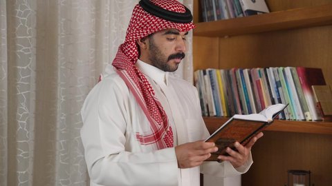 الاهتمام بالعلم والثقافة والدين ، تعزيز مفهوم المعرفة ، تنمية المهارات الفكرية ،  قضاء الوقت بالمطالعة ، ممارسة الهوايات المفضلة،رجل عربي خليجي سعودي يرتدي الزى التقليدي مع الشماغ يقف بجانب مكتبه خشبيه ، يأخذ منها كتاب ويبدأ بالقراءه ،  الاستمتاع بالهدوء والراحة داخل المنزل