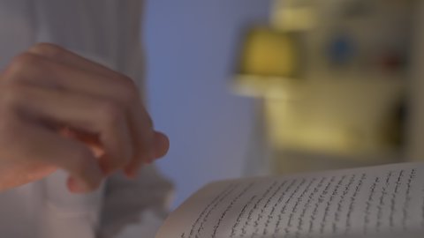 تنمية المهارات الفكرية ، تصوير من الجانب لرجل عربي خليجي سعودي يرتدي الزى التقليدي مع الشماغ يجلس على الأريكة في غرفة المعيشة ويقوم بقراءة كتاب ،قضاء الوقت بالمطالعة والثقافة، الاستمتاع بقراءة الروايات والقصص ، تعزيز مفهوم الثقافة والمعرفة ،ممارسة الهوايات المفضلة، الاستمتاع بالهدوء والراحة داخل المنزل