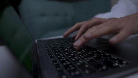 إنجاز المهام المطلوبة عبر اللابتوب، دمج التقنيات المتطوره فى الحياه اليوميه ، وظائف ومهن سعودية، ادارة الأعمال عن بعد، التطور والتكنولوجيا الحديثة، تصوير مقرب ليد رجل عربي خليجي سعودي يرتدي الزى التقليدي مع الشماغ يجلس على اريكه في غرفة مظلمه ويستخدم جهاز الحاسوب المحمول ، استخدام جهاز اللابتوب