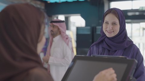 ايماءات السعادة و السرور، الإستعداد للدخول الى صالة العرض، تصوير مقرب من الخلف لإمرأه عربيه سعوديه خليجيه تبيع المأكولات والمشروبات في ردهة الإستقبال داخل السينما تقوم بالنقر على الشاشة، سينما ومسرح، أنشطه ترفيهيه، زبونه تقوم بشراء سناكس