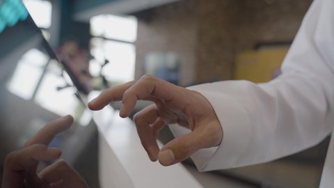 مشاهدة الأفلام والعروض المسرحية في السينما، تصوير مقرب ليد لرجل عربي سعودي خليجي يرتدي الزي السعودي التقليدي يقوم بحجز تذكرة لمشاهدة فلم في صالة السينما، سينما ومسرح، أنشطه ترفيهيه