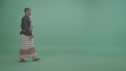 Spending enjoyable times, gestures of walking and going to a specific place, events and recreational activities in Saudi Arabia, a portrait of a Saudi Arabian Gulf man wearing the Jazan outfit, full-body, green background, chroma.