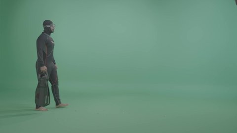 تعابير السير و المشي للذهاب الى مكان ما، الاستعداد لمغامرة الغوص في أعماق البحر، مفهوم الأنشطة البحرية والترفيهية، بورترية لرجل عربي خليجي سعودي يرتدي بدلة الغوص ونظارات السباحة، الجسم بالطول الكامل ، خلفية خضراء ، كروما