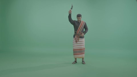 الأنشطة والفعاليات الترفيهية بالمملكة العربية السعودية، الاحتفال باليوم الوطني السعودي 23 سبتمبر, بورتريه لشاب عربي خليجي سعودي يرتدي الزي الجيزاني يقوم بالرقص الشعبي , ايماءات السعادة و السرور، خلفية خضراء، كروما