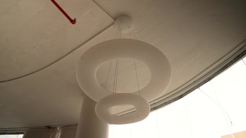 ديكور حديث للمكاتب والمنازل، تصوير مقرب لإضاءة دائرية معلقة بتصميم أنيق، لمسات فنية في التصميم الداخلي