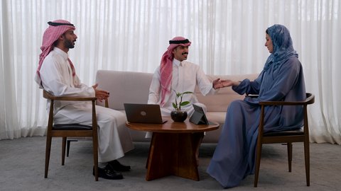 استخدام الأجهزة والتقنيات الحديثة، مناقشة الخطط وشرح مهام الاعمال، تطوير الاعمال والشركات، الحوارات والنقاشات ضمن الفريق, زملاء عمل عرب سعوديين خليجيين في اجتماع, ارتداء اللباس السعودي التقليدي