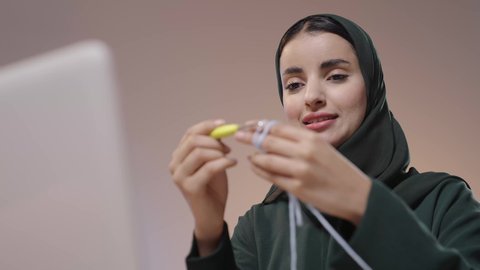 الإبداع في ابتكار موديلات جديدة، ممارسة مهنة الخياطة، تصوير مقرب لامراة عربية خليجية سعودية محجبه ترتدي العباءة السوداء تستخدم إبرة الكروشيه وخيوط الصوف ، أعمال تقليدية شعبية, فنون الخياطة و التصميم