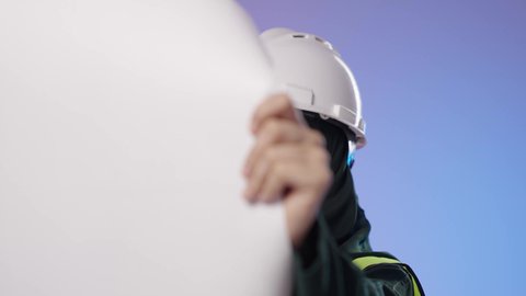 متابعة مراحل التنفيذ الهندسي, المخططات الانشائية المعمارية, تنمية وتطور السعودية على يد أبناء الوطن, بورترية مقرب لمهندسة عربية خليجية سعودية مبتسمة ترتدي الخوذة وسترة الحماية تمسك بيدها المخطط تنظر إلى شي ما