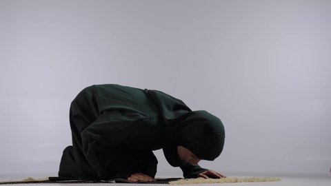 أهمية الالتزام بالصلاة على وقتها, التقرب من الله تعالى بأداء الفرائض والتزام أوامره, بورتريه لإمرأة عربية خليجية سعودية ترتدي الحجاب والعباءة السوداء تسجد لله تعالى, مفهوم أركان الإسلام, خلفية ملونه