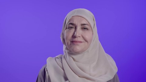 الاهتمام بالاناقة والاهتمام بالمظهر الخارجي، تعابير السعادة والسرور،تصوير مقرب لامراه عربيه خليجيه سعوديه كبيره بالسن ترتدي العباءة والجاب تنظر الى الكاميرا بإيماءات الفرح والثقة بالنفس