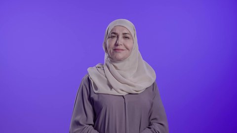 الاهتمام بالاناقة والاهتمام بالمظهر الخارجي، تعابير السعادة والسرور،تصوير مقرب لامراه عربيه خليجيه سعوديه كبيره بالسن ترتدي العباءة والجاب تنظر الى الكاميرا بإيماءات الفرح والثقة بالنفس