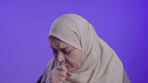 الشعور بالمرض والكحة،  تصوير لامراه عربيه خليجيه سعوديه كبيره بالسن ترتدي العباءه والحجاب  تعاني من السعال، الانفلونزا والتهاب الرئه، الاصابة بفايروس كورونا