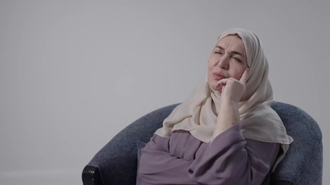 التمعن والتركيز والتخطيط للمستقبل ،محاولة إيجاد حل لمشكلة ما, إيماءات الحيرة والقلق, النظر بشرود إلى مكان ما, تصوير لامراه عربيه خليجيه سعوديه كبيره بالسن ترتدي العباءه والحجاب تجلس على كرسي ، تنظر بعيداً بتعابير التفكير والتأمل