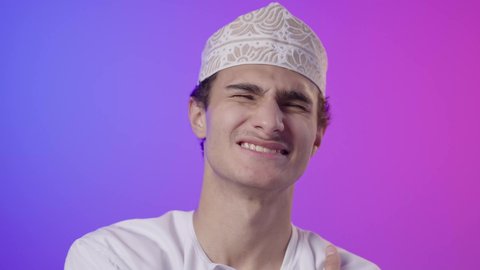 التهاب العضلات والمفاصل، شد عضلي في الرقبه، الحاجه للراحة و وضع خطة علاجية ، الإحساس بالتعب والإرهاق, بورتريه لولد  عربي خليجي عماني يرتدي الدشداشة و الكمة يضع يده على رقبته بإيماءات الألم، خلفية ملونه