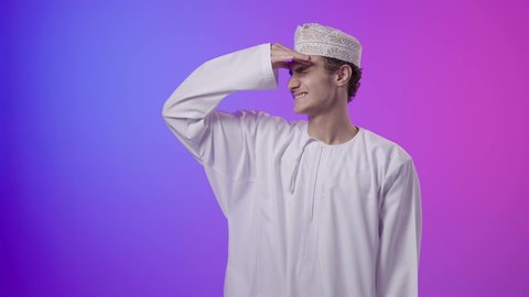 الاجهاد والضغط النفسي, الشعور بالإرهاق وفقدان التركيز, الاحساس بالشقيقية والصداع النصفي, بورتريه لولد عربي خليجي عماني يرتدي الدشداشة و الكمه يضع يديه على رأسه ويغمض عينيه بإيماءات ألم الرأس الشديد, خلفية ملونه