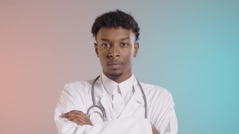 ملامح الرجوله والجديه, طبيب عربي خليجي سعودي يرتدي الثوب التقيلدي والسماعه الطبيه, الوقوف بايدي متقاطعه, خلفيه ملونه