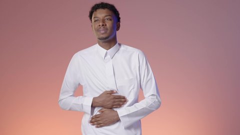 امراض والتهابات الجهاز الهضمي، الحاجة للدواء ووضع خطة علاجية، شاب عربي خليجي سعودي يرتدي الثوب التقليدي يضع يديه علي بطنه, ايماءه التعب الشديد والالم, خلفيه ملونه