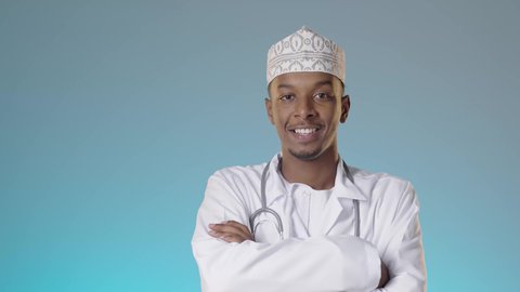 مفهوم الطب والرعاية الصحية، العمل في القطاع الطبي في سلطنة عمان، طبيب عربي خليجي عماني يرتدي الدشداشة والكمة والزي الخاص بالمهنة و يضع السماعة الطبية و يقف باستقامة ينظر إلى الكاميرا يإيماءات الثقة بالنفس