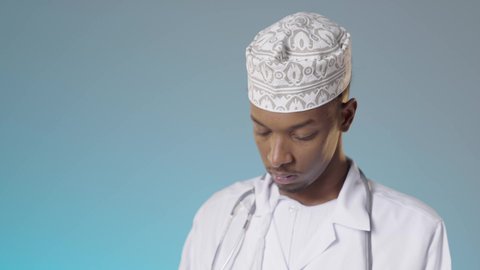 Integrating modern technical devices into medicine, reading medical reports via a tablet, an Arab Gulf Omani doctor wearing a dishdasha, a kummah, and a white coat, reviewing the results of examinations in the medical record