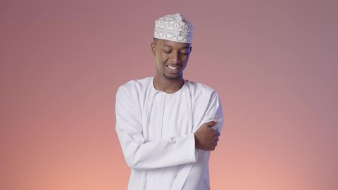 الأوجاع والآلام العصبية والعضلية، طلب المساعده والحاجه للعلاج، التهاب العضلات والمفاصل، شاب عربي خليجي عماني يرتدي الدشداشة و الكمه يضع يده على كتفه بايماءات الألم والتعب والأرهاق