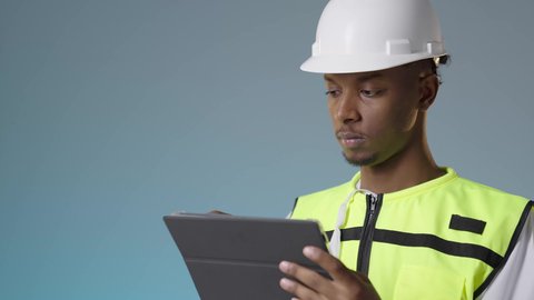 الإشراف على مخططات المشاريع الهندسية، مفهوم الانشاءات المعمارية، مهندس عربي خليجي عماني يرتدي سترة عاكسة و خوذة بيضاء يمسك بيديه تابلت، مهنة ووظيفة للشباب