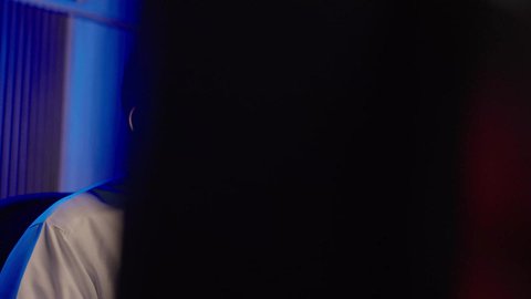 التأمل والإبداع الفني أمام الشاشة، تصوير من الجانب لمونتيرعربي خليجي سعودي يرتدي الثوب الابيض و سماعات الرأس  يقوم التفكير العميق والتحليل البصري، مفهوم الإبداع في صناعة المحتوى المرئي