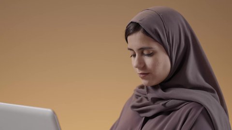 تطور طريقة التدريس في المملكة السعودية، بورتريه لطالبة عربية خليجية سعودية تدرس باستخدام الحاسوب، لكتابة والنقر على لوحة المفاتيح، المنهاج المتطور والتعليم الالكتروني في الجامعات، استخدام جهاز تقني حديث في التعلم والدراسة، خلفية بني