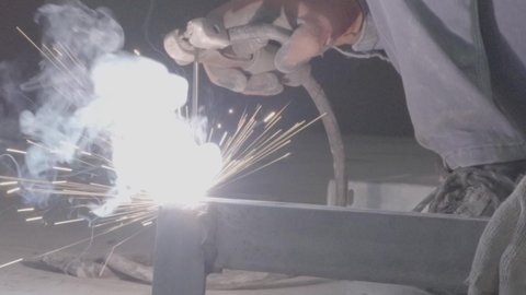 وظيفة ومهنة صناعية شبابية، تجهيز وتوصيل الحديد بمعدات وأدوات خاصة، متابعة سير العمل في ورش الحدادة بمهارة وإتقان، تصوير مقرب لعامل عربي خليجي سعودي يرتدي القفازات للحماية يقوم بصقل الأجزاء المعدنية وتشكيلها