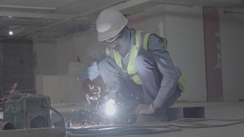 A youth industrial job and profession, preparing and connecting iron with special equipment and tools, skillfully and perfectly following up on the progress of work in blacksmith workshops, a close-up of a Saudi Arabian Gulf worker wearing protective gloves while polishing and shaping metal parts
