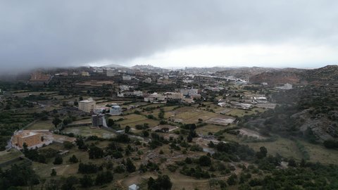 سلاسل جبال أبها والنماص الصخرية، التضاريس والطرق الحجرية الوعرة، تصوير جوي للبيئة الجبلية في منطقة عسير، السحب البيضاء والجو الضبابي المغطي للقمم العالية، الطبيعة الخضراء والمنتزهات والحدائق الجميلة، الأشجار والنباتات على سفوح الجبل
