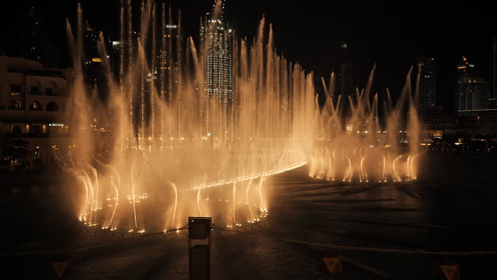 التصاميم العروض المميزة للأماكن الترفيهية في مدينة دبي، وجهات جذب واستقطاب السياح من حول العالم، الفن الهندسي المعماري في بناء الأبراج وناطحات السحاب، معالم سياحية مشهورة في الإمارات العربية المتحدة، تصوير لعرض النافورة الراقصة المائية في دبي مول في وقت الليل 