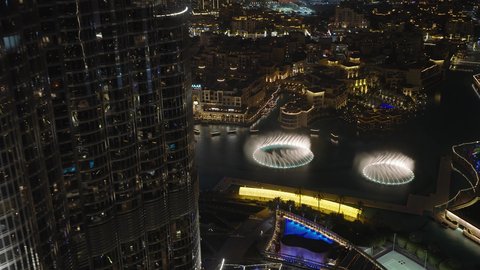 التصاميم العروض المميزة للأماكن الترفيهية في مدينة دبي، وجهات جذب واستقطاب السياح من حول العالم، الفن الهندسي المعماري في بناء الأبراج وناطحات السحاب، معالم سياحية مشهورة في الإمارات العربية المتحدة، تصوير لعرض النافورة الراقصة المائية في دبي مول في وقت الليل 