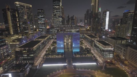 حركة مرور السيارات في الشوارع والطرقات، النمو والتقدم والتوسع العمراني، تصوير درون جوي  للأبراج وناطحات السحاب المضيئة ليلا في مدينة دبي، الفن الهندسي المعماري للمباني والمنشآت في الإمارات العربية المتحدة